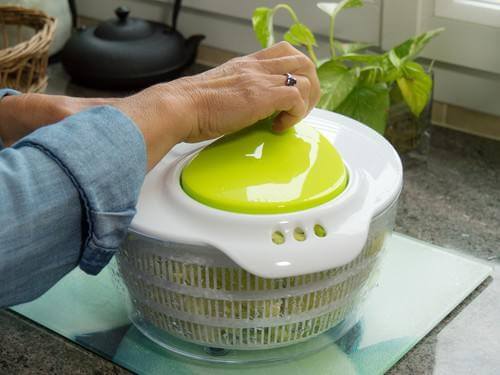hand of a woman spinning salad in the kitchen